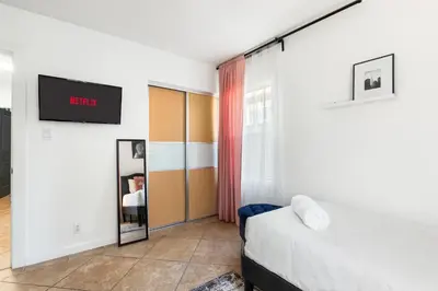 a bedroom with a bed and a tv on a wall at Modern Oasis with Pool & Jacuzzi near Universal Studios in Los Angeles