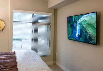 a bedroom with a flat screen tv on the wall at 1 Bedroom XL Condo with King bed, Garden View, Parking Included in Los Angeles