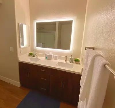 a bathroom with two sinks and a large mirror at 1 Bedroom XL Condo with King bed, Garden View, Parking Included in Los Angeles