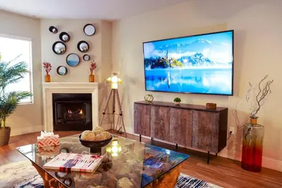 a living room with a large tv on the wall at 1 Bedroom XL Condo with King bed, Garden View, Parking Included in Los Angeles