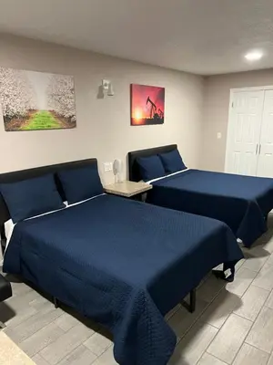 two beds in a room with blue sheets at Lone Oak Studio Suites in Bakersfield