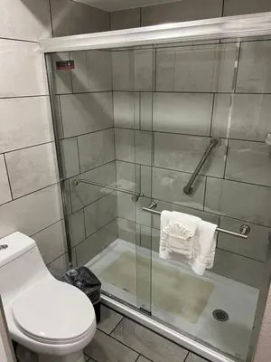 a bathroom with a glass shower with a toilet at Lone Oak Studio Suites in Bakersfield