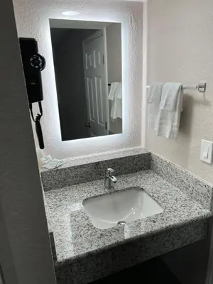 a bathroom with a sink and a mirror at Lone Oak Studio Suites in Bakersfield