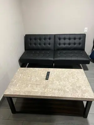 a black couch sitting in a living room with a coffee table at Lone Oak Studio Suites in Bakersfield