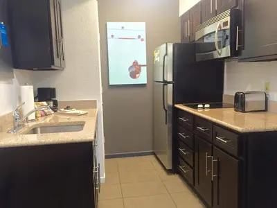 a kitchen with a sink and a refrigerator at Hyatt House LAX Manhattan Beach in El Segundo