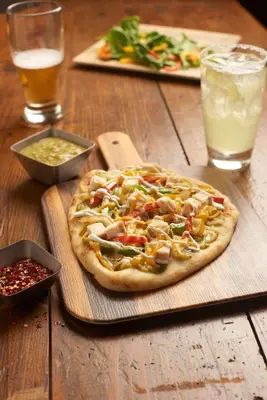 a pizza sitting on top of a wooden table at Hyatt House LAX Manhattan Beach in El Segundo