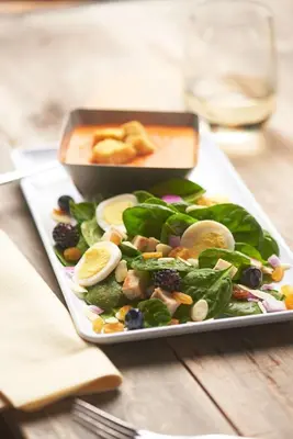 a plate of food with a salad on a table at Hyatt House LAX Manhattan Beach in El Segundo