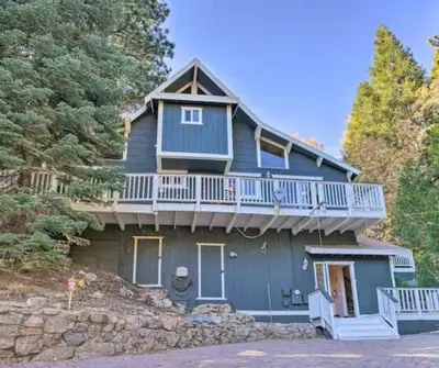 a blue house with a balcony on top of it at Cocos Cottage Getaway Running Springs in Running Springs
