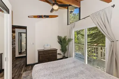 a bedroom with a bed and a large window at Cocos Cottage Getaway Running Springs in Running Springs