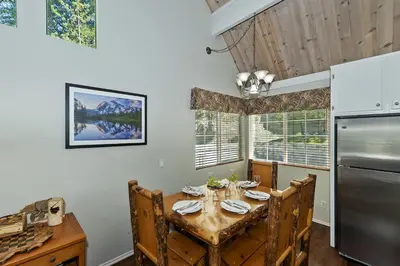 a kitchen with a table and a refrigerator at Lake Arrowhead Fishermans Haus in Lake Arrowhead
