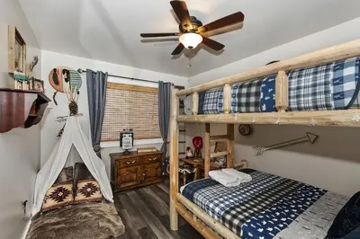 a bedroom with two bunk beds and a ceiling fan at Lake Arrowhead Grass Valley Cabin in Lake Arrowhead