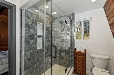 a bathroom with a shower and a toilet at Quiet Mountain Cabin in Lake Arrowhead