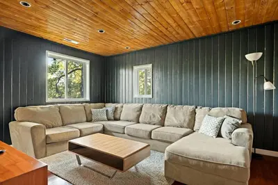 a living room with a couch and a table at Quiet Mountain Cabin in Lake Arrowhead