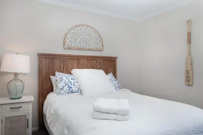 a bedroom with a white bed with blue and white pillows at Lake Arrowhead Matterhorn Views in Lake Arrowhead