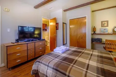 a bedroom with a bed and a dresser with a television at The Muddy Moose- Spacious Family Getaway in Lake Arrowhead
