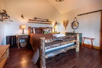 a bedroom with a large bed with a wooden floor at The Muddy Moose- Spacious Family Getaway in Lake Arrowhead