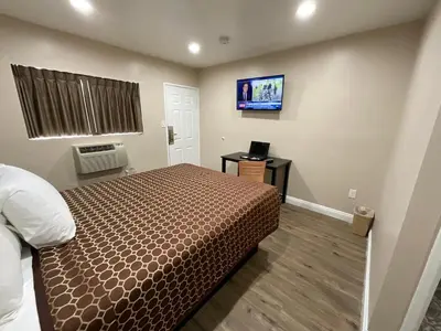 a bedroom with a bed and a flat screen tv at State Motel in South Gate