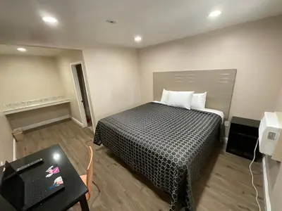 a bedroom with a bed and a table and a television at State Motel in South Gate