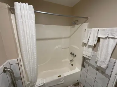 a bathroom with a shower and a bath tub with towels at State Motel in South Gate