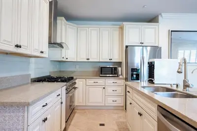 a kitchen with white cabinets and stainless steel appliances at 17-19ppl BTW Dsny Hllywd GarageParking Yard Grill in Monterey Park