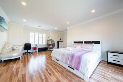 a white bedroom with a large bed and a chair at 17-19ppl BTW Dsny Hllywd GarageParking Yard Grill in Monterey Park