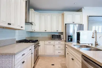 a kitchen with white cabinets and stainless steel appliances at 17-19ppl BTW Dsny Hllywd GarageParking Yard Grill in Monterey Park
