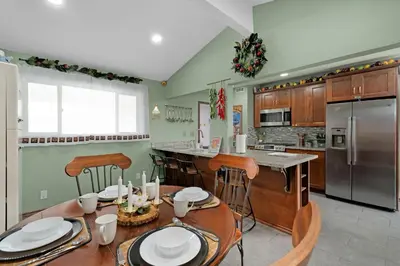 a kitchen with a table and chairs and a refrigerator at Pixar Pier by OC Adventure Homes in Anaheim