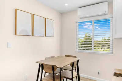 a dining room with a table and chairs and a window at Central Hollywood Apartment in Los Angeles