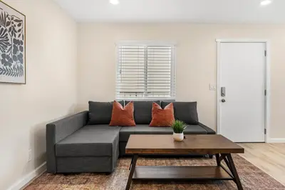 a living room with a gray couch and a table at Central Hollywood Apartment in Los Angeles