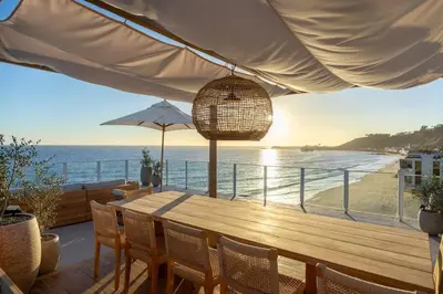 a table with chairs and a view of the beach at Aqualina Best View in Malibu by Stay Awhile Villas in Malibu