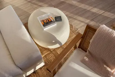 a table with a book on it next to a chair at Aqualina Best View in Malibu by Stay Awhile Villas in Malibu