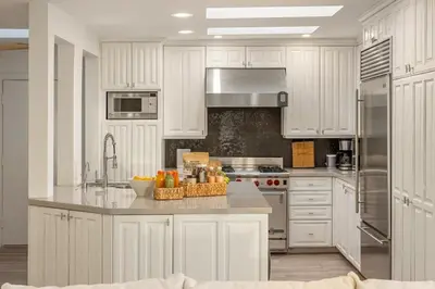 a kitchen with white cabinets and a counter with a sink at Aqualina Best View in Malibu by Stay Awhile Villas in Malibu