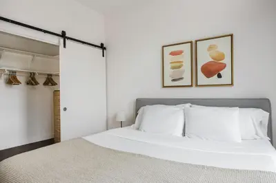 a bedroom with a white bed and two pictures on the wall at Blueground Pasadena gym elev near bars LAX-1231 in Los Angeles