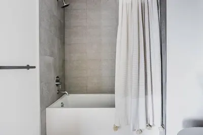 a white bath tub with a shower curtain in a bathroom at Blueground Pasadena gym elev near bars LAX-1231 in Los Angeles