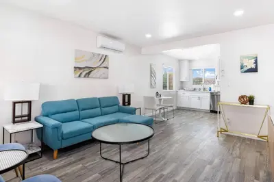 a living room with a blue couch and a table at Cozy House Minutes From Downtown in Los Angeles