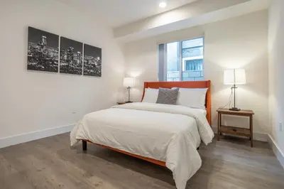 a white bedroom with a bed and a window at LA Cityscapes in Los Angeles