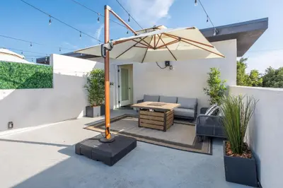 a patio with a table and an umbrella at LA Cityscapes in Los Angeles