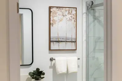 a bathroom with a mirror and a shower with towels at Luxe Townhouse Near Downtown LA in Los Angeles