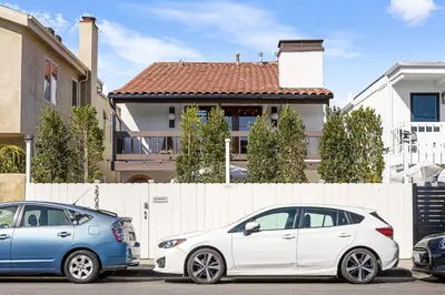 two cars parked in a parking lot in front of a house at Venice Beach Villa in Los Angeles
