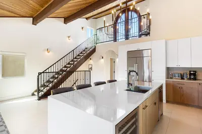 a kitchen with a white counter top and a staircase at Venice Beach Villa in Los Angeles