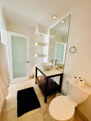a bathroom with a toilet and a sink and a mirror at Cool Apartment in West Hollywood in Los Angeles