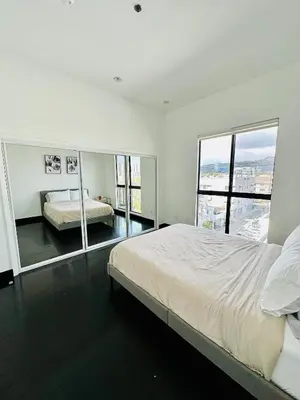 a white bedroom with a bed and a large window at Cool Apartment in West Hollywood in Los Angeles