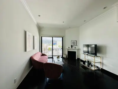 a living room with a couch and a television at Cool Apartment in West Hollywood in Los Angeles