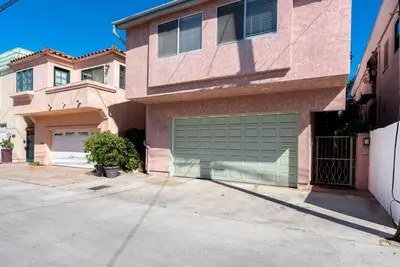 a house with two garage doors in a driveway at House on the canal in Venice in Los Angeles