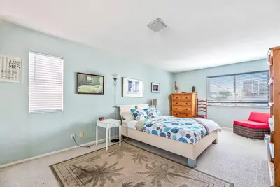 a bedroom with blue walls and a bed and a window at House on the canal in Venice in Los Angeles