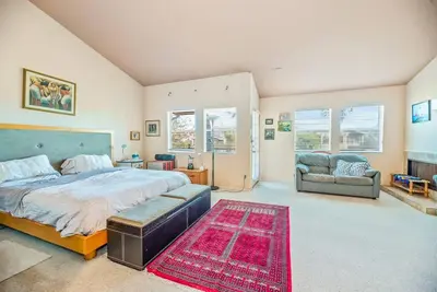 a bedroom with a bed and a couch and a rug at House on the canal in Venice in Los Angeles