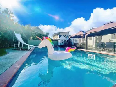 a pool with a unicorn float in a swimming pool at New Charming Spacious Disneyland Pool Home in Garden Grove