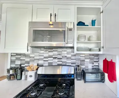 a kitchen with a stove and a microwave at New Charming Spacious Disneyland Pool Home in Garden Grove