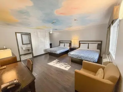 a living room with two beds and a couch at Super 7 Motel - Anaheim Packing District & Disneyland in Anaheim