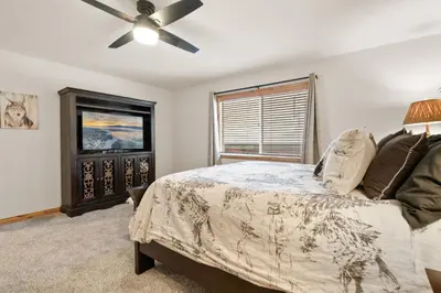 a bedroom with a bed and a ceiling fan at Arctic Wolf at Summit Base - 4 Bedroom log cabin at the base of Snow Summit in Big Bear Lake